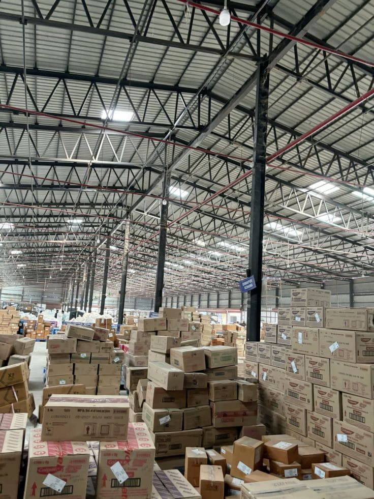 Tumpukan karton di gudang beratap rangka baja